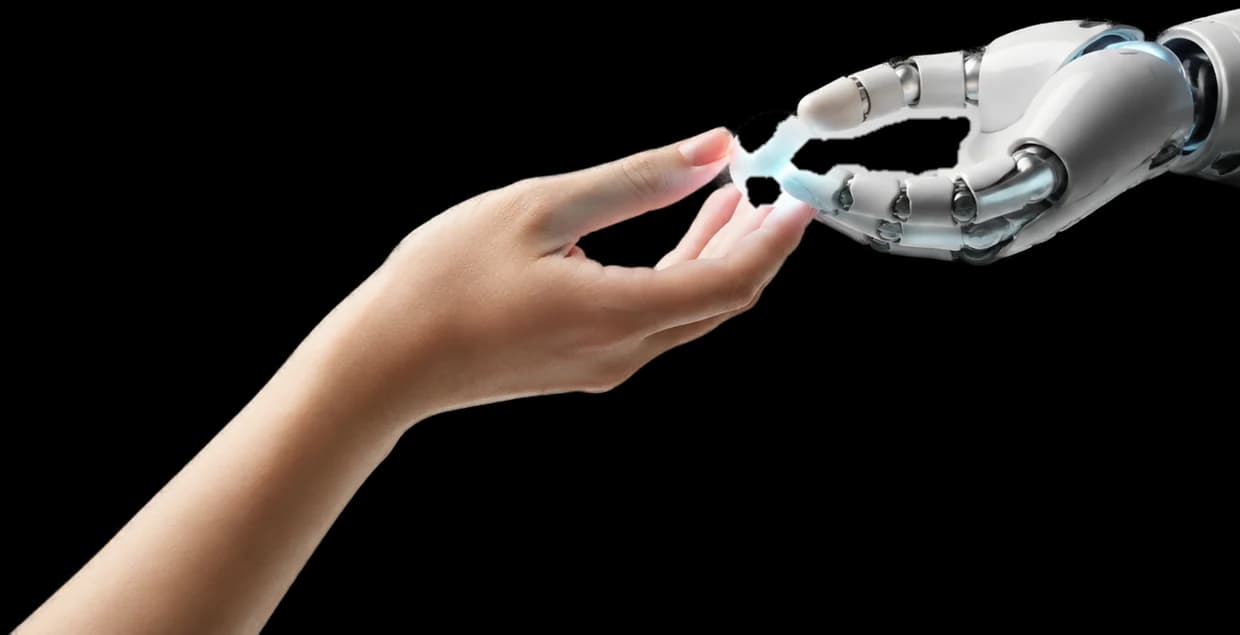 人の手からロボットの手へ、光る球体が手渡されている